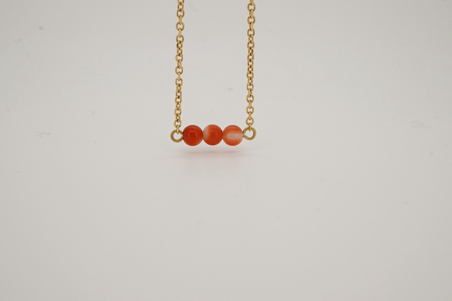 A recent yellow metal and coral bead set necklace, 40cm, gross weight 3 grams. Condition - good